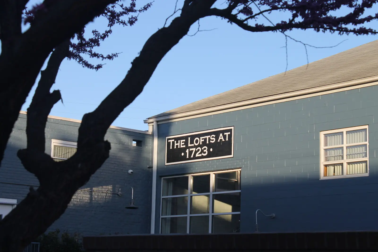 The Lofts at 1723, the converted blue industrial building in Scott’s Addition, its name lettered above the entrance.